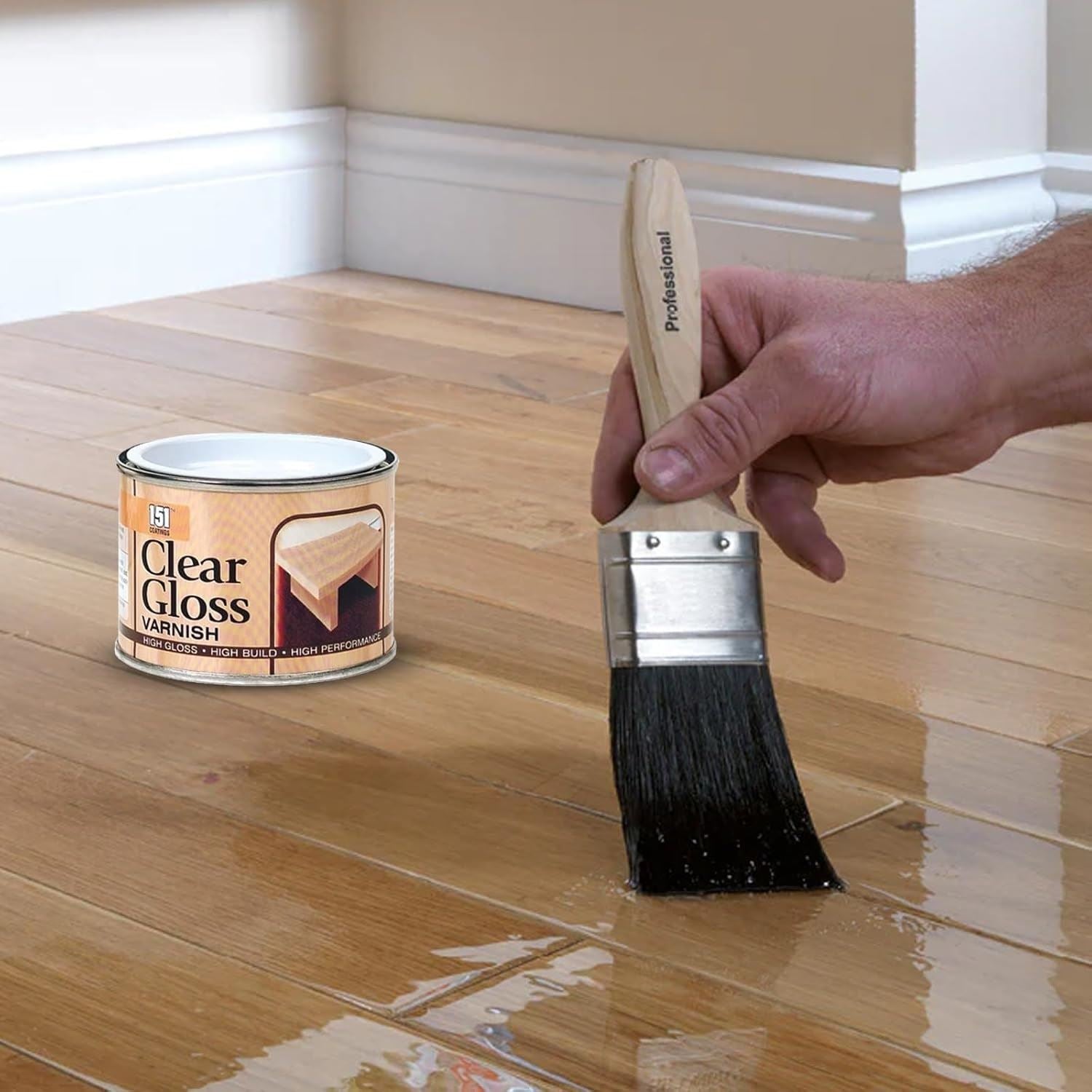 151 Clear Gloss Varnish Paint in tin with a brush applying varnish on wooden flooring