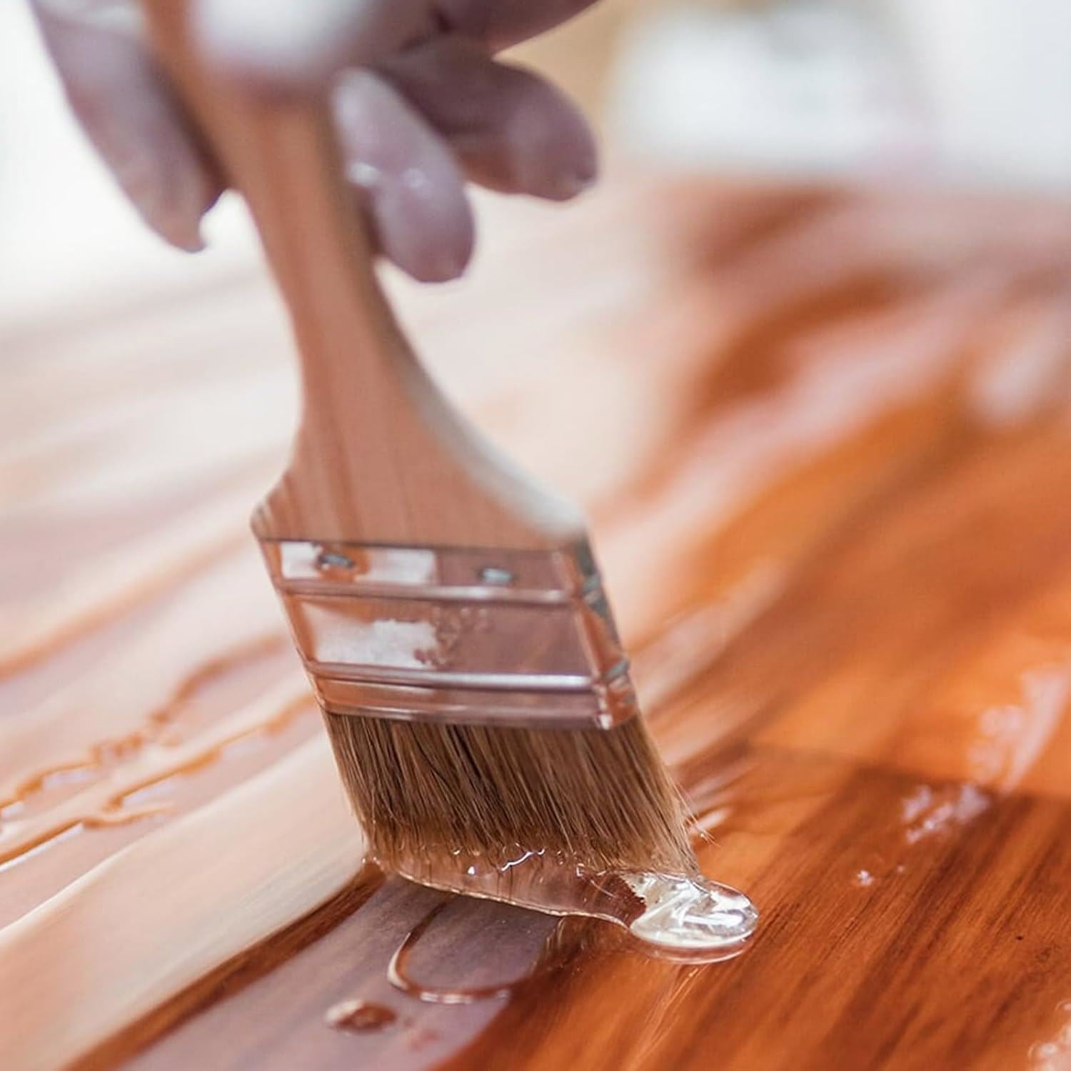 Applying clear gloss varnish paint with a brush to a wooden surface for a glossy finish