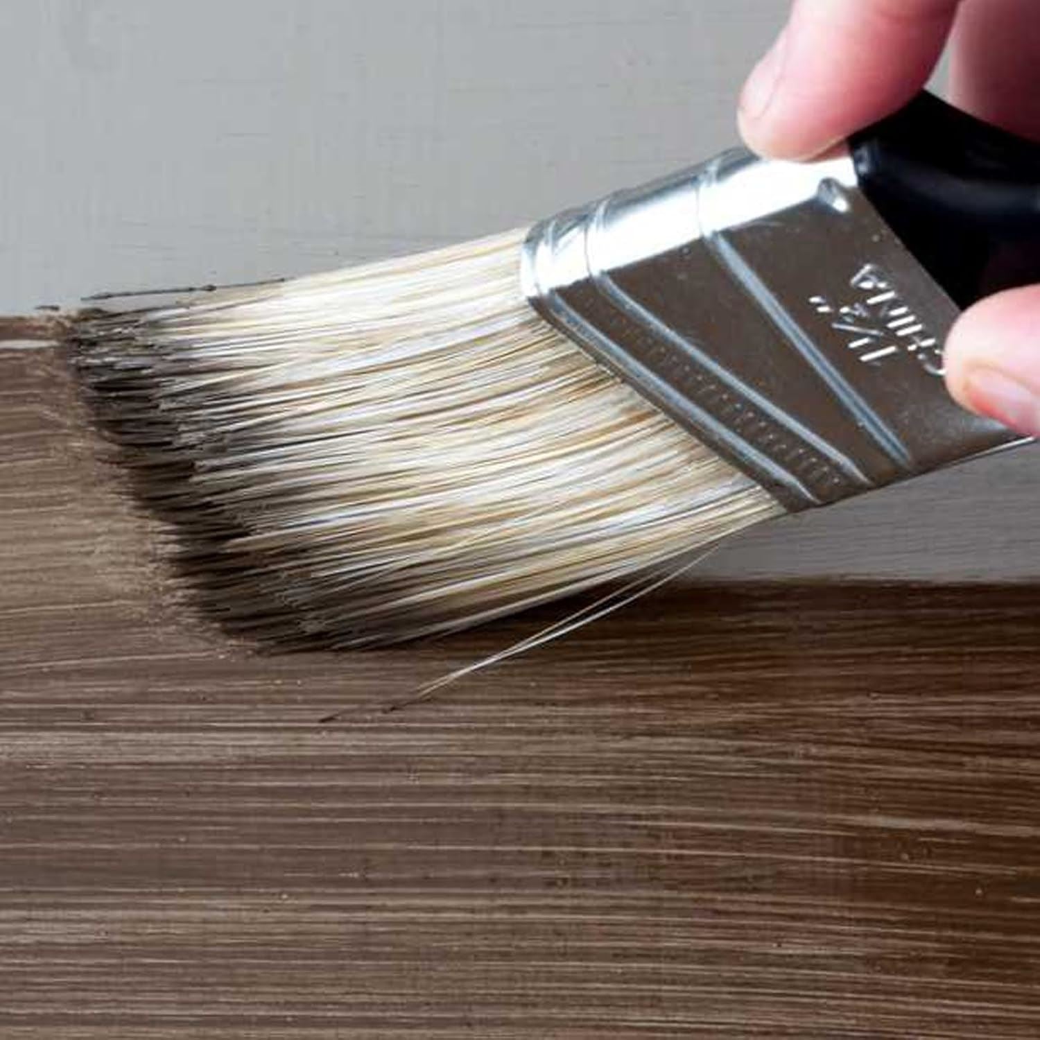 Applying dark oak varnish 180ml to wood surface with a paintbrush for a smooth finish