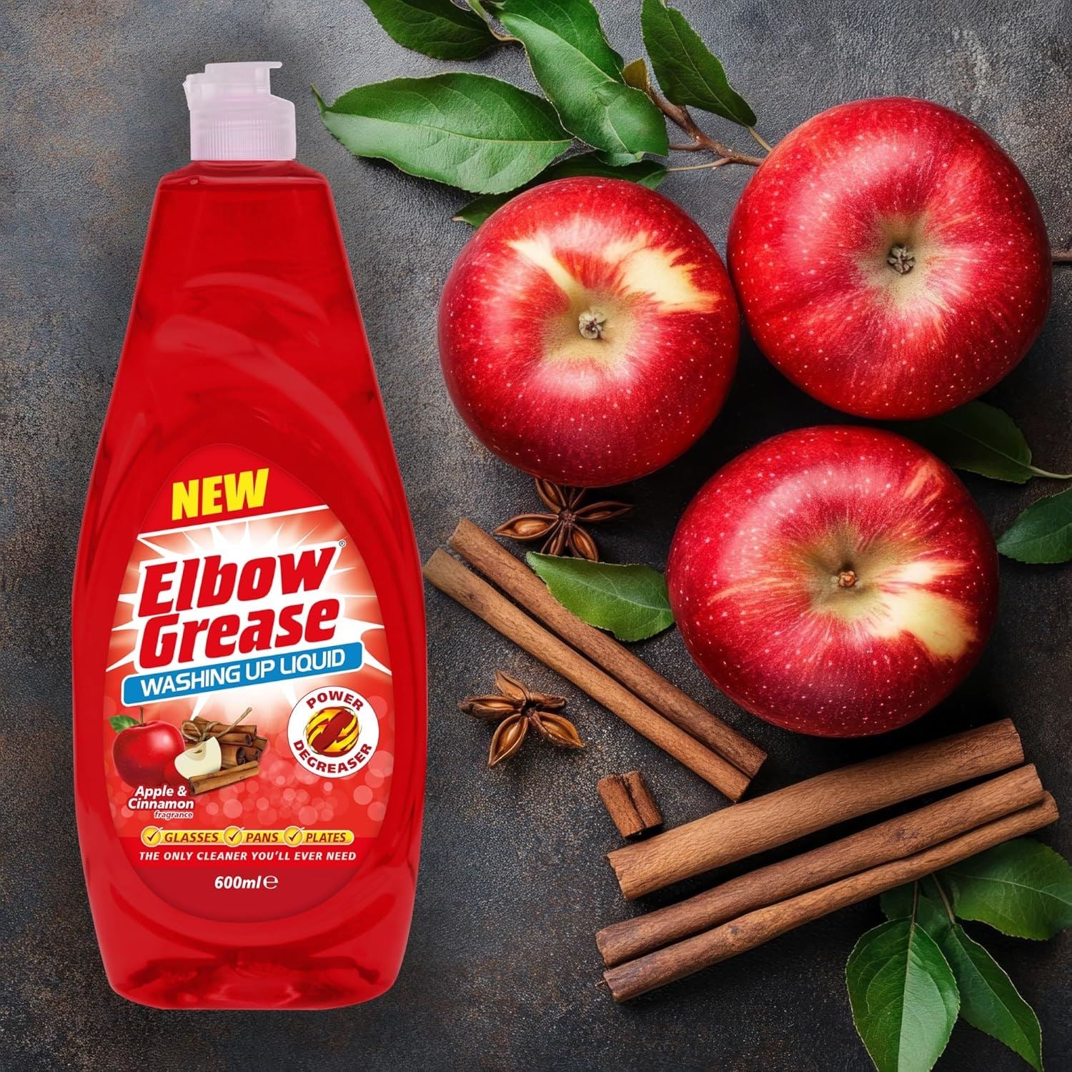 Elbow Grease washing up liquid in a red bottle with apple and cinnamon scent, surrounded by apples and cinnamon sticks