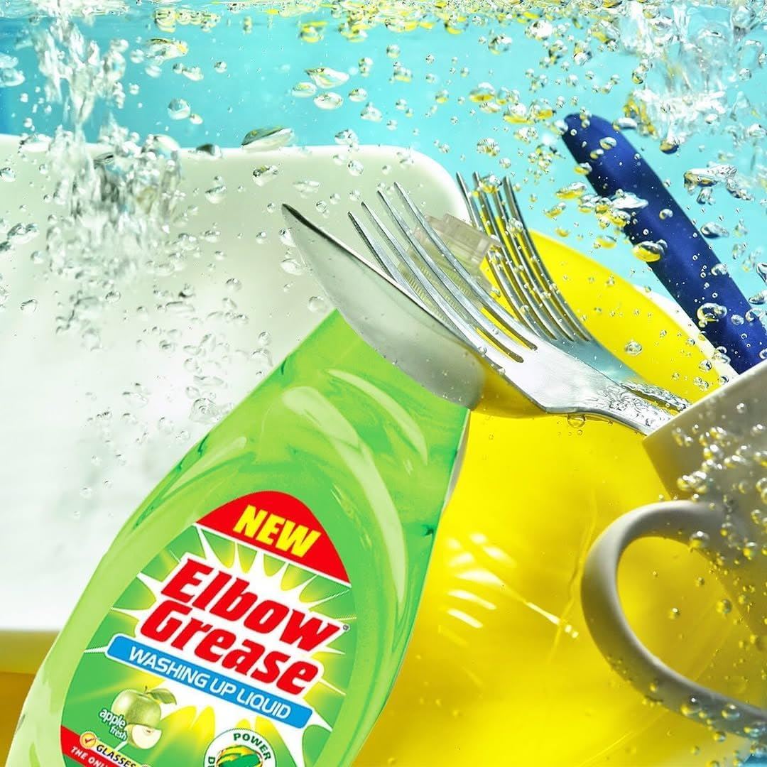 Elbow Grease washing up liquid in green bottle with dishes and cutlery in soapy water