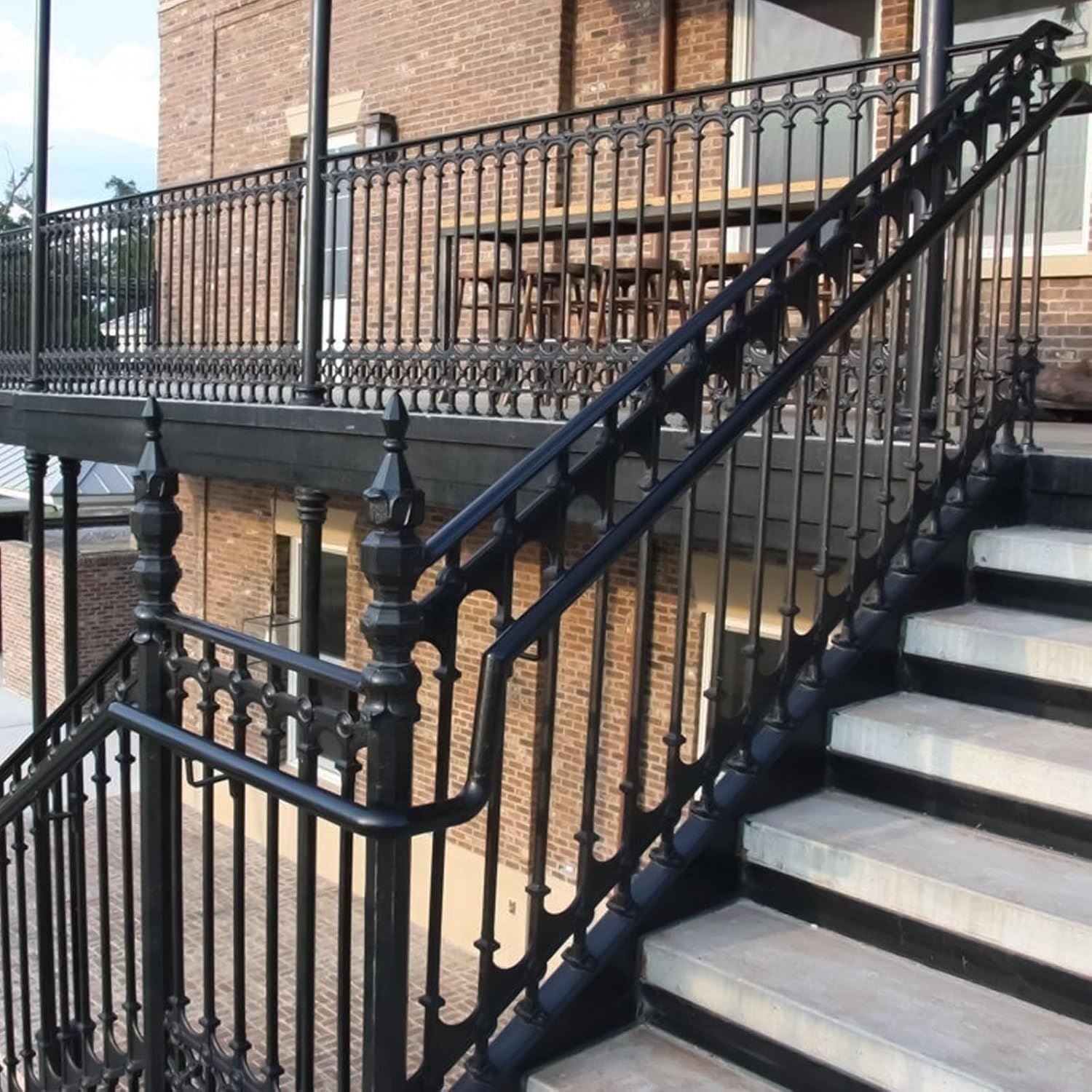 Iron gate black gloss paint coating on ornate metal railing and staircase for lasting durability