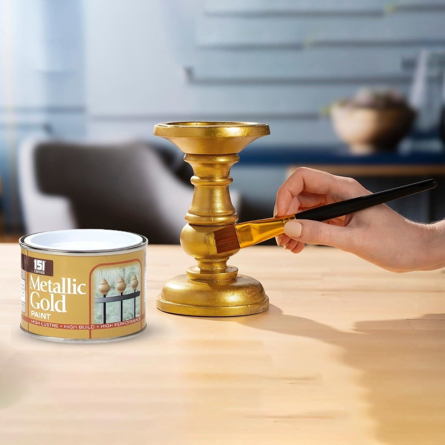 151 metallic gold paint tin shown while painting a decorative candlestick