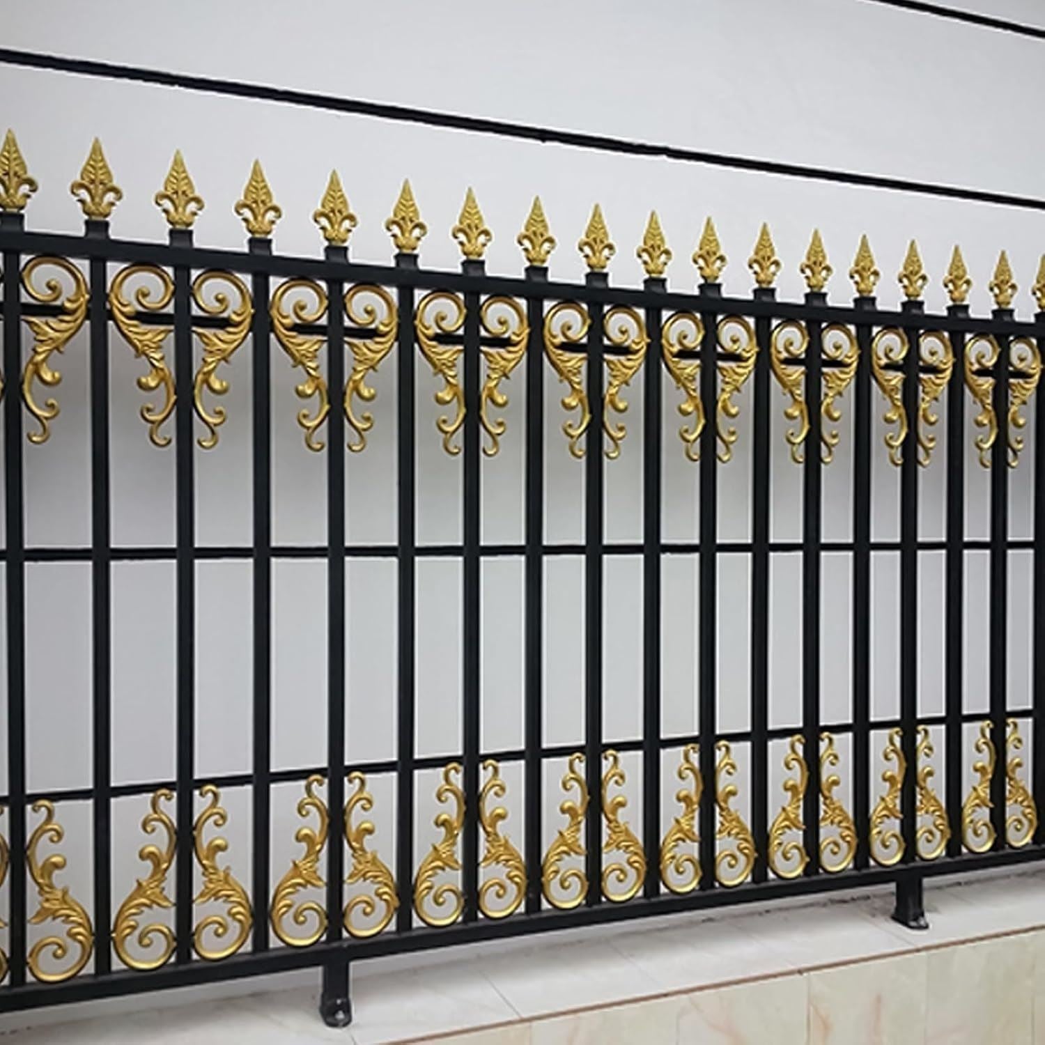 Elegant wrought iron fence with ornate designs and accents painted in metallic gold paint tin