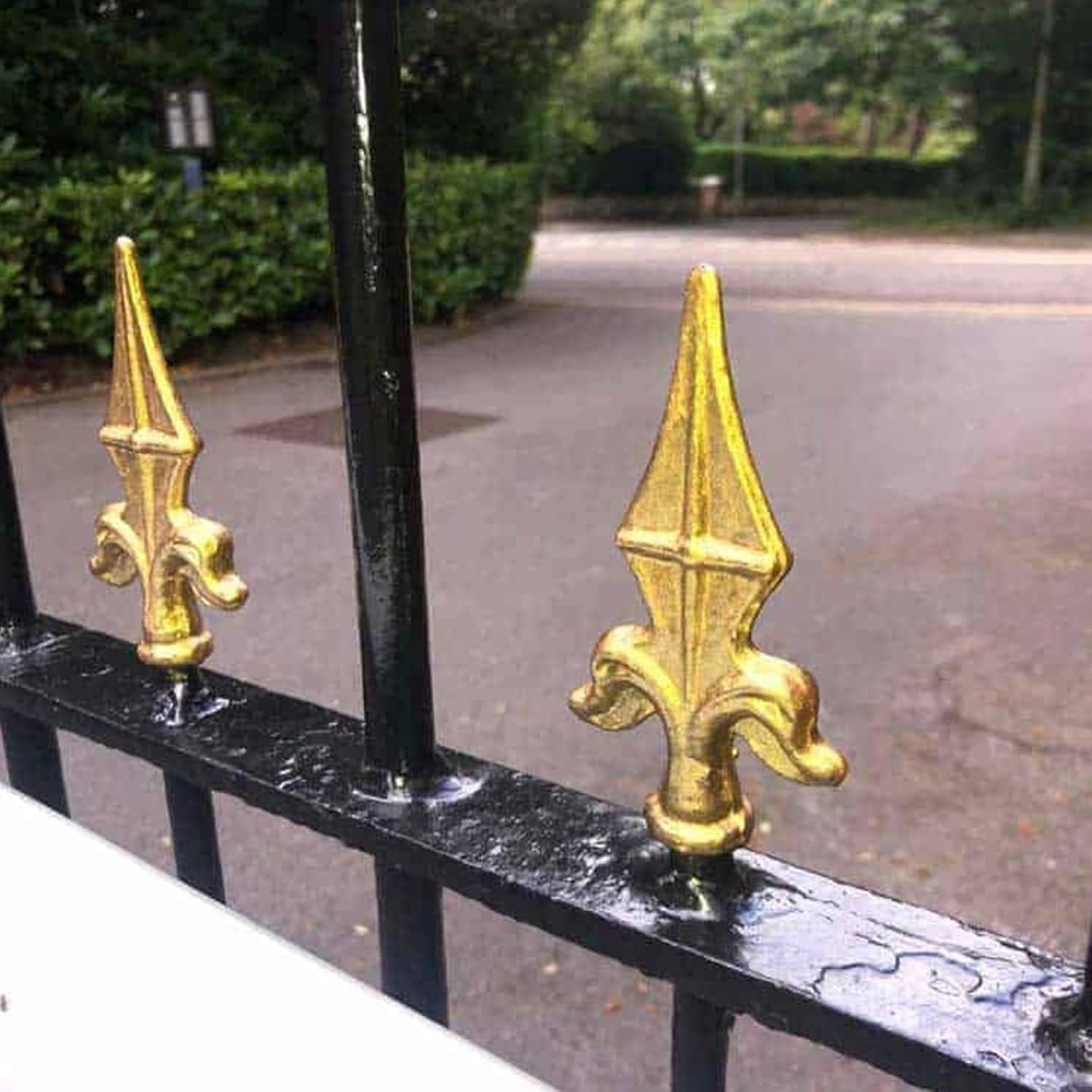 Close-up of decorative gate finials painted with metallic gold paint tin for an elegant finish
