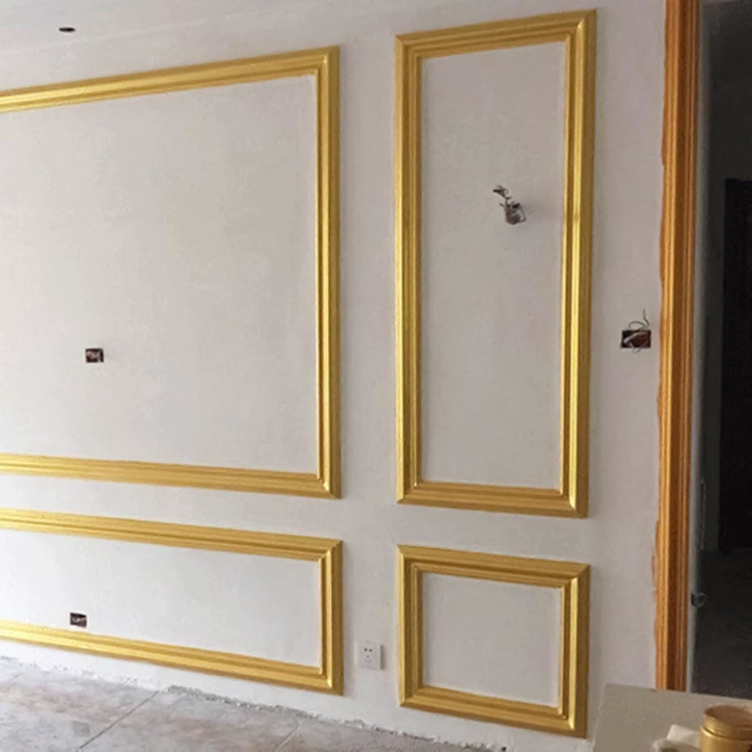 Interior wall adorned with frames painted using metallic gold paint tin for an elegant finish