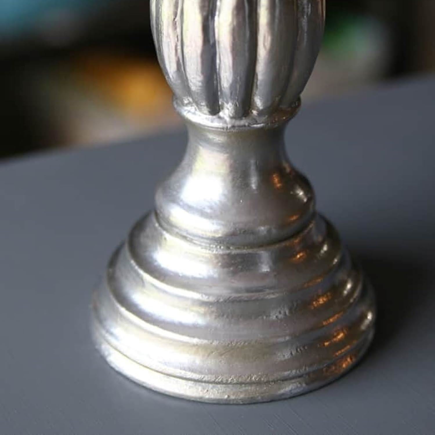 Close-up of a decorative base in shiny finish painted with metallic silver paint tin