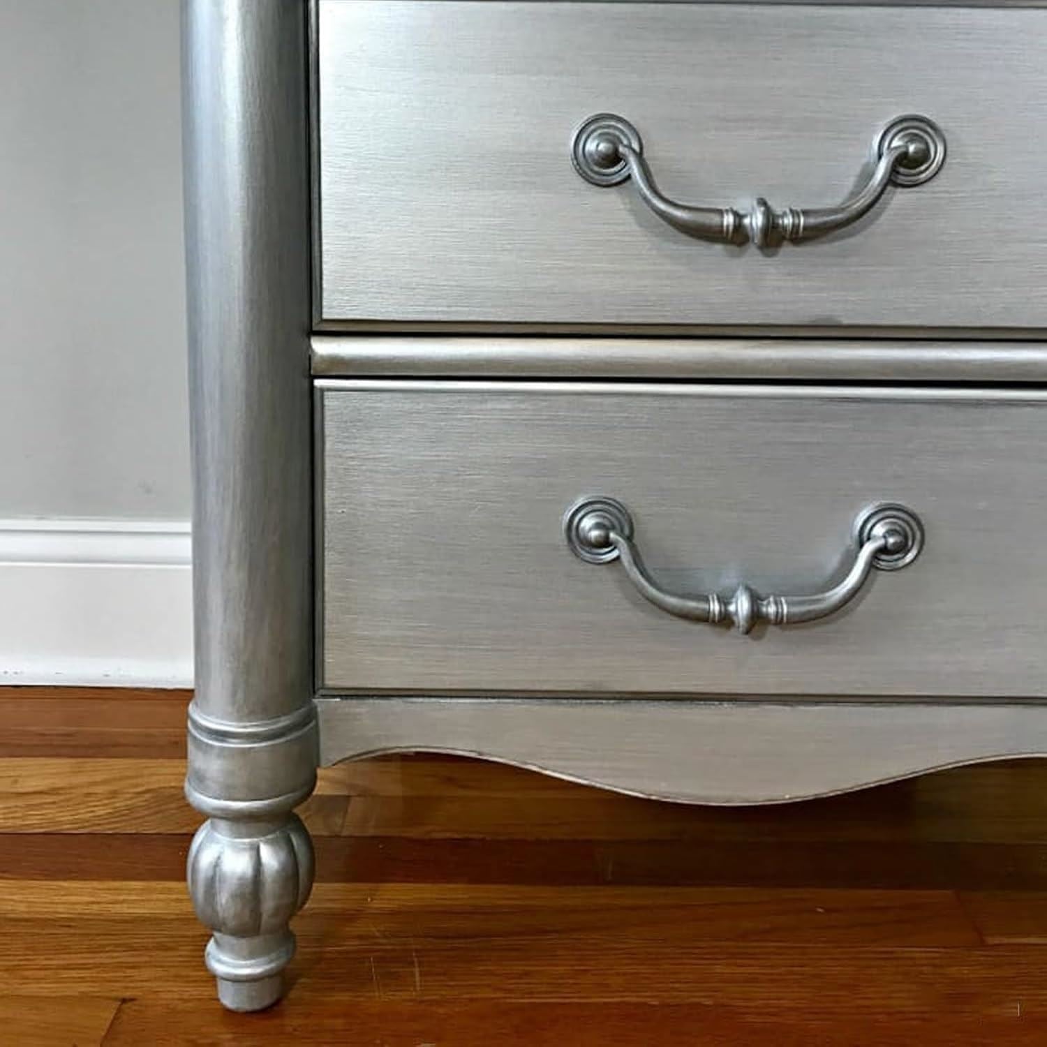 Metallic silver paint tin beside a stylish wooden dresser with decorative handles