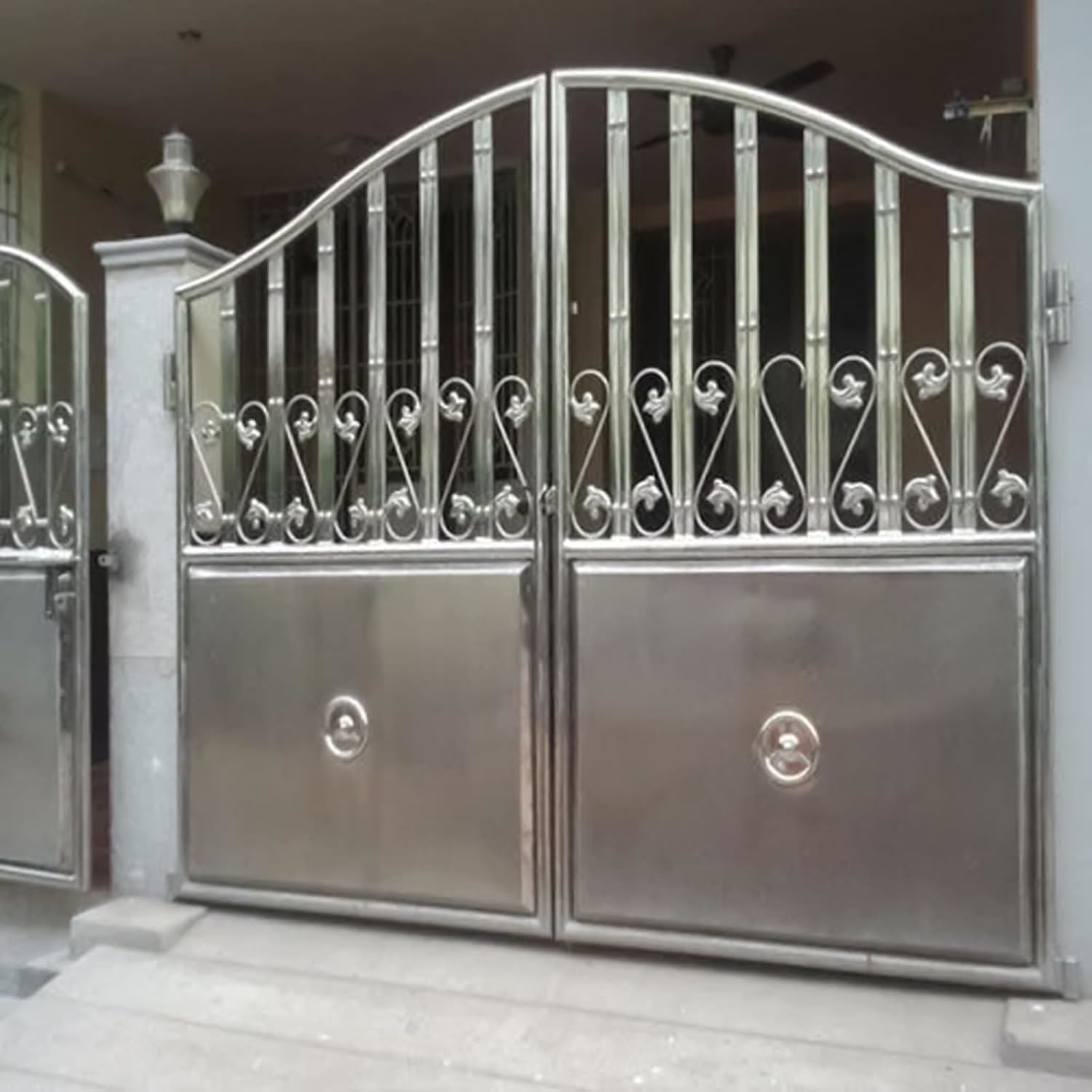 Metal gates with intricate designs showcasing a metallic silver paint tin finish for stylish home entrances