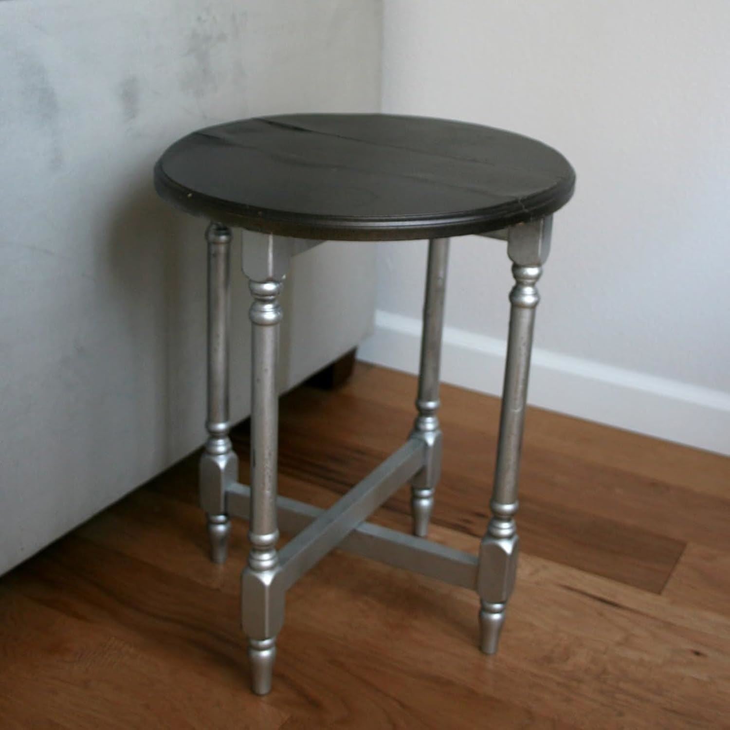 Round side table with a black top and metallic silver paint tin legs for stylish home decor