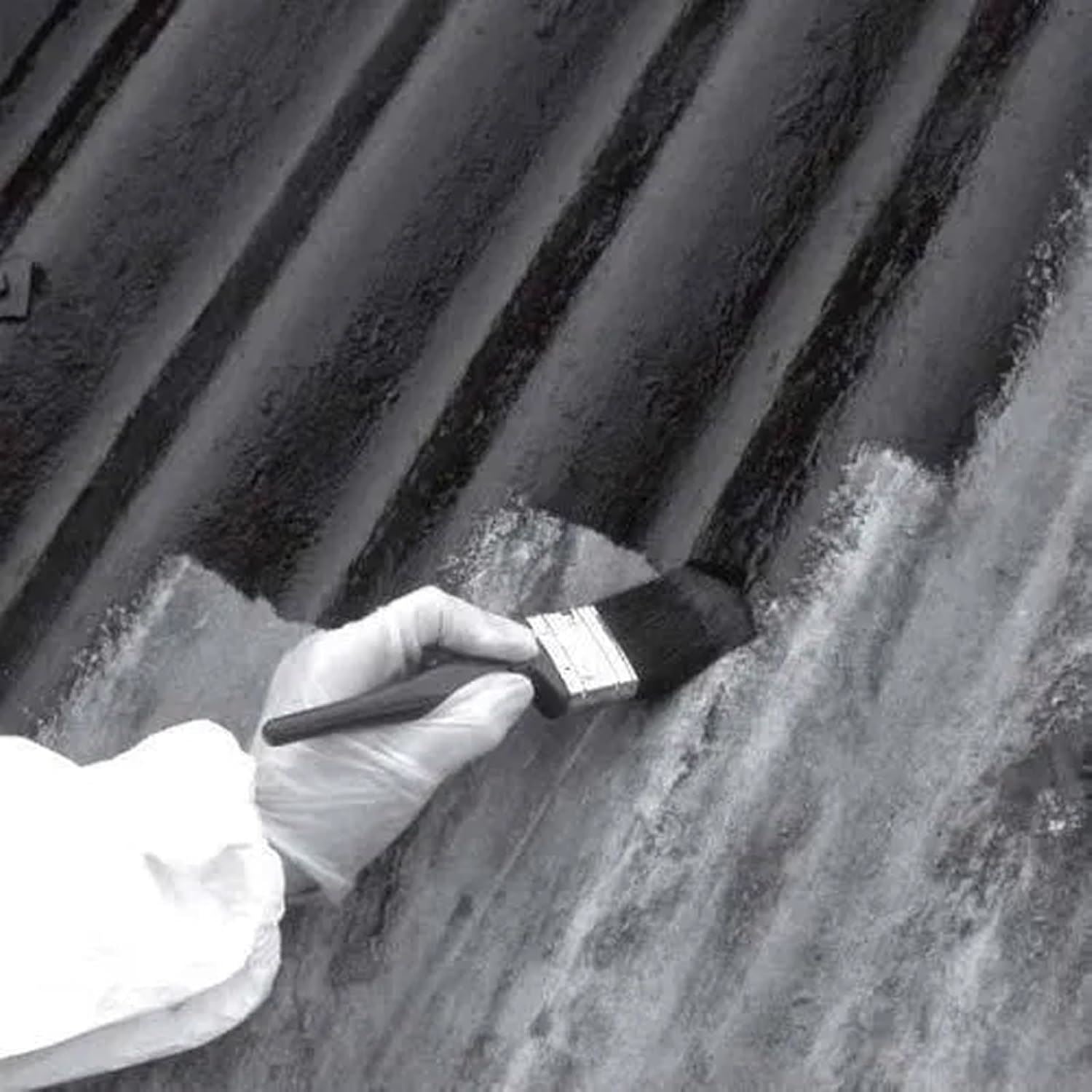 Person applying non-drip black gloss paint tin to a textured surface with a paintbrush