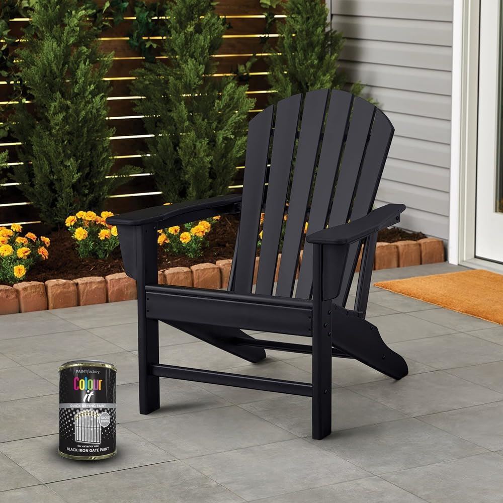 Tin of black iron gate gloss paint beside an Adirondack chair on a patio with greenery